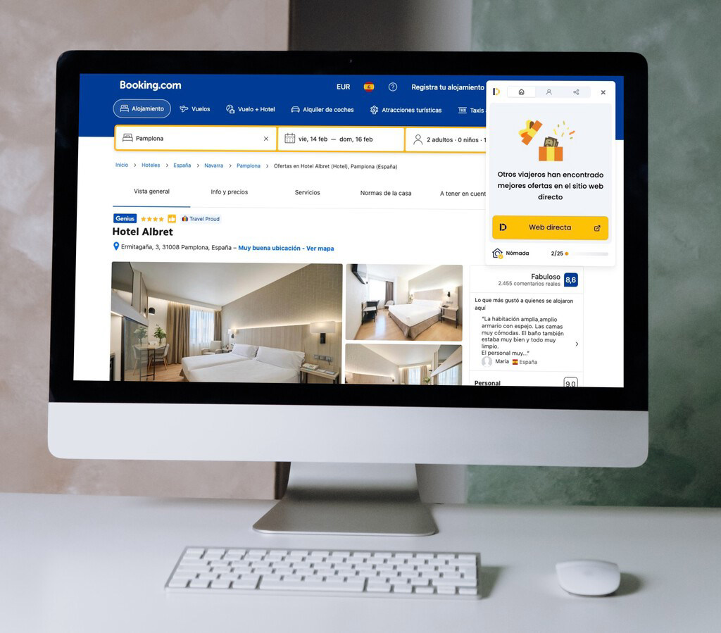 Imagen de un ordenador que muestra la página de Booking.com con información sobre el Hotel Albrett en Pamplona, España, incluyendo fotos de habitaciones y detalles de tarifas.